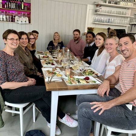 Das Team von exaktaktiv sitzt gemeinsam an einem Tisch in einem Restaurant
