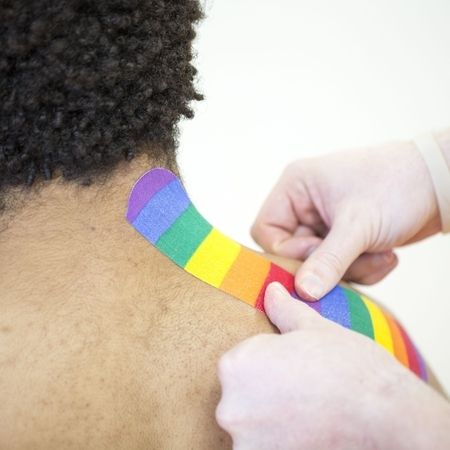 Ein Arzt bringt Kinesiotape am Nacken eines Patienten an