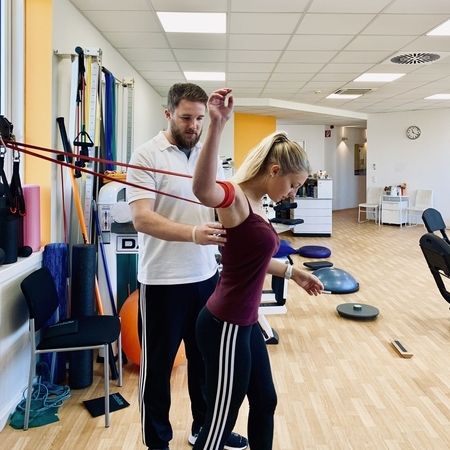 Patientin führt eine Flossingübung am Arm durch