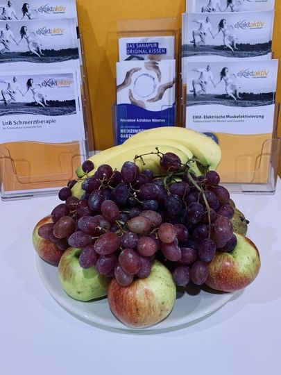 Ein Teller voll mit Äpfeln, Bananen und Weintrauben